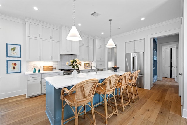 2604 E Seaside Dr, Galveston, TX 77550 - kitchen featuring high end fridge, light wood-style floors, a breakfast bar, baseboards, and ornamental molding