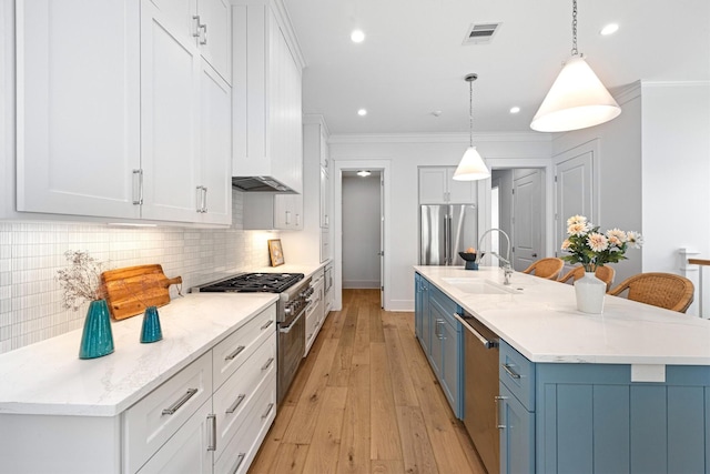 2604 E Seaside Dr, Galveston, TX 77550 - kitchen with a sink, appliances with stainless steel finishes, white cabinetry, decorative backsplash, and a center island with sink