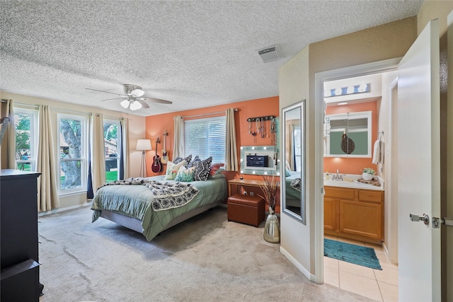 23910 Spring Day Ln, Spring, TX 77373 - bedroom featuring a sink, light carpet, a textured ceiling, ceiling fan, and ensuite bath