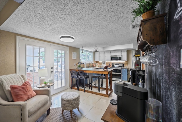 23910 Spring Day Ln, Spring, TX 77373 - living room with light tile patterned floors, french doors, and a textured ceiling