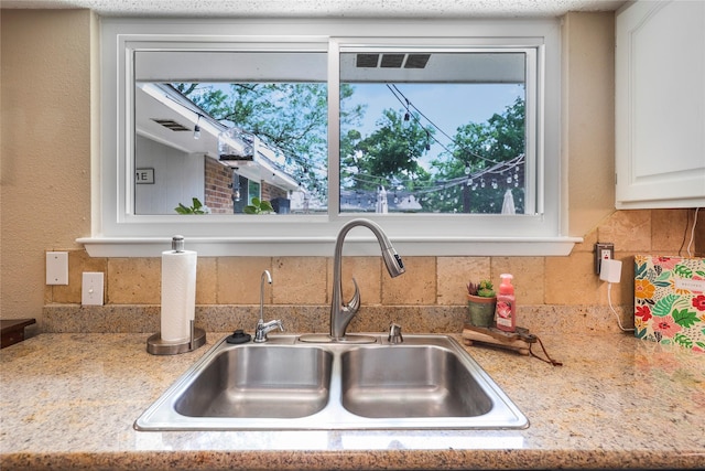 23910 Spring Day Ln, Spring, TX 77373 - kitchen view of a sink, decorative backsplash, light countertops, and white cabinets