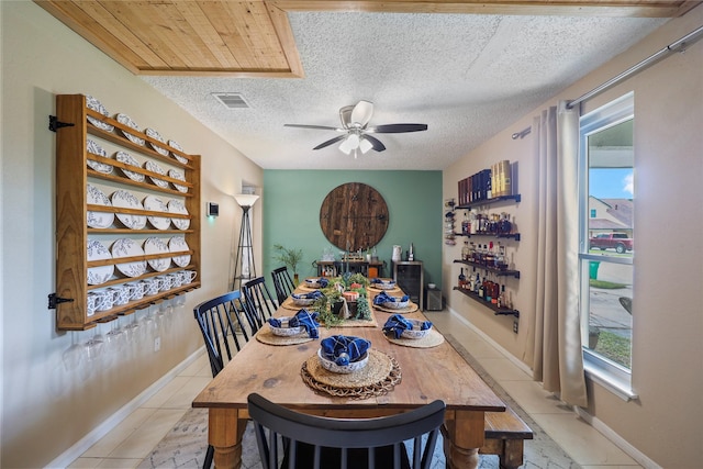 23910 Spring Day Ln, Spring, TX 77373 - dining area with ceiling fan, a textured ceiling, baseboards, light tile patterned floors, and a bar