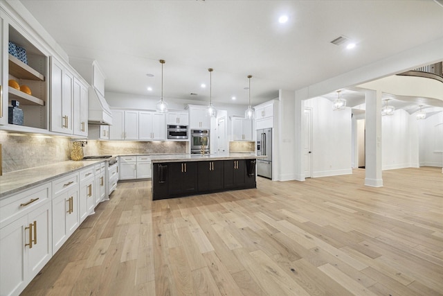 19 Sanctuary Trl, Missouri City, TX 77459 - kitchen featuring appliances with stainless steel finishes, custom range hood, white cabinetry, tasteful backsplash, and light wood-style floors