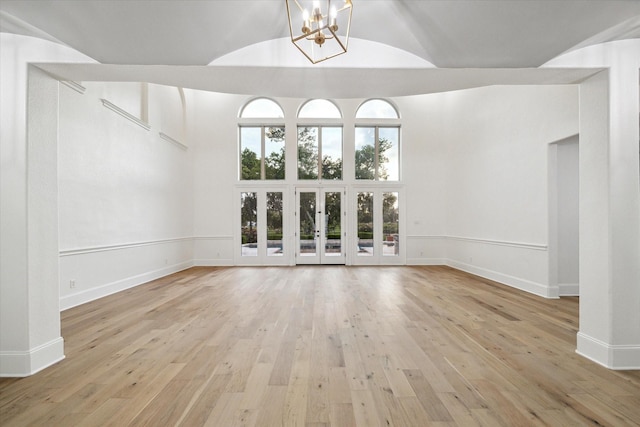 19 Sanctuary Trl, Missouri City, TX 77459 - unfurnished living room with high vaulted ceiling, a chandelier, and light wood-type flooring