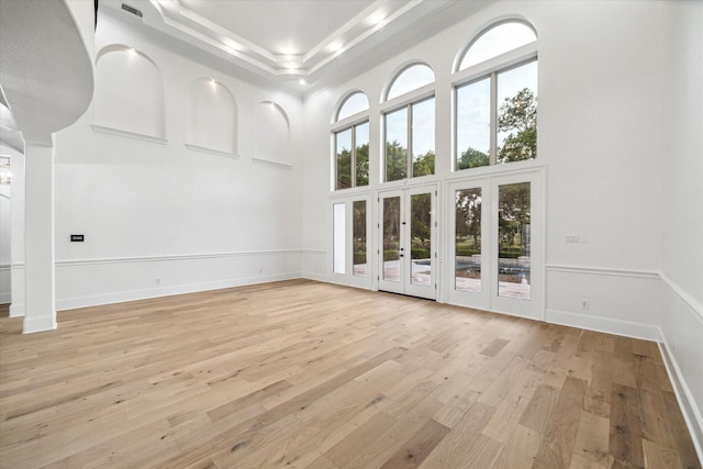 19 Sanctuary Trl, Missouri City, TX 77459 - unfurnished living room featuring a high ceiling, light wood finished floors, recessed lighting, a raised ceiling, and ornamental molding