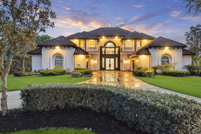 19 Sanctuary Trl, Missouri City, TX 77459 - mediterranean / spanish house featuring a tile roof, french doors, stucco siding, a balcony, and a yard