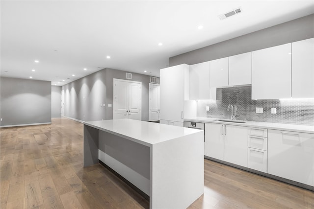 4521 San Felipe St Unit 2601, Houston, TX 77027 - kitchen featuring a sink, modern cabinets, white cabinetry, recessed lighting, and backsplash