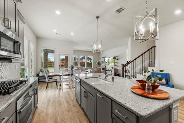 29510 Enchanted Breeze Ln, Katy, TX 77494 - kitchen with a sink, appliances with stainless steel finishes, a chandelier, a kitchen island with sink, and recessed lighting