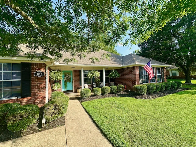 1308 Hagan St, Crockett, TX 75835 - ranch-style home with brick siding, a front yard, and a shingled roof