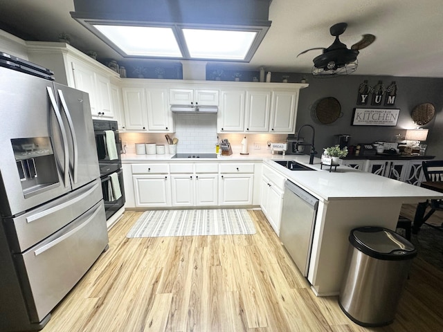 1308 Hagan St, Crockett, TX 75835 - kitchen with appliances with stainless steel finishes, a peninsula, white cabinets, ceiling fan, and light wood-style floors