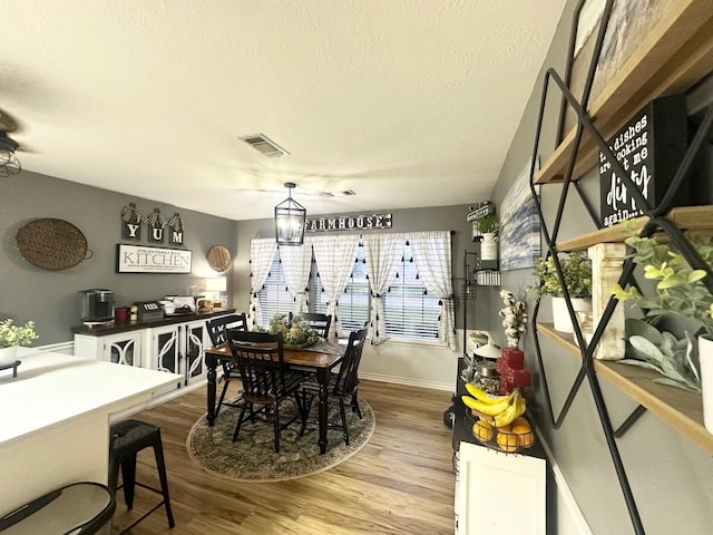 1308 Hagan St, Crockett, TX 75835 - dining space featuring wood finished floors, baseboards, and a textured ceiling