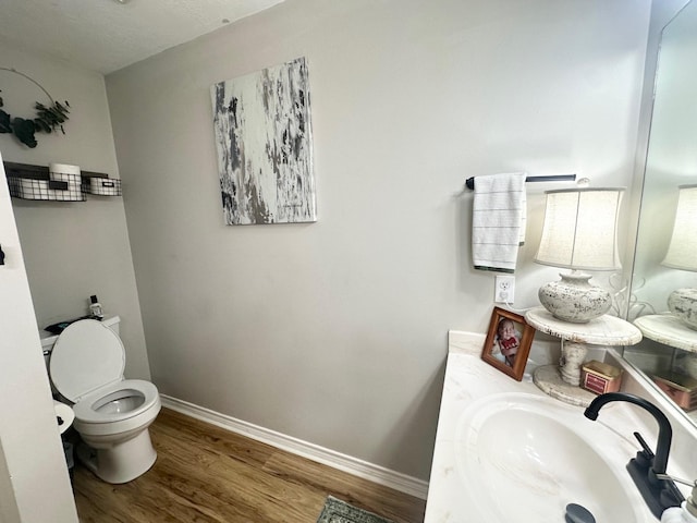 1308 Hagan St, Crockett, TX 75835 - bathroom featuring wood finished floors, toilet, vanity, and baseboards