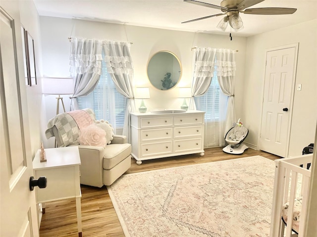 1308 Hagan St, Crockett, TX 75835 - bedroom with wood finished floors, a ceiling fan, baseboards, and a nursery area