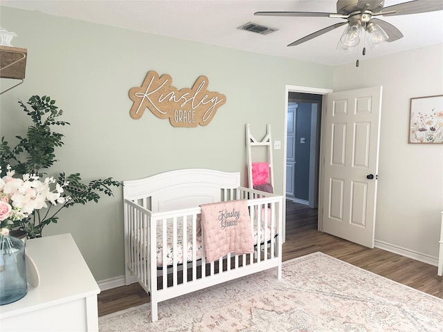 1308 Hagan St, Crockett, TX 75835 - bedroom featuring wood finished floors, a crib, baseboards, and ceiling fan