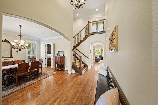 77 Big Trl, Missouri City, TX 77459 - entrance foyer with arched walkways, a chandelier, stairs, wood finished floors, and ornamental molding