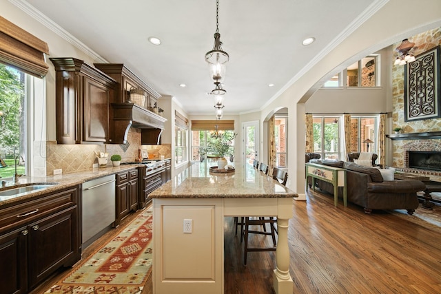 77 Big Trl, Missouri City, TX 77459 - kitchen with stainless steel appliances, a sink, light wood-type flooring, open floor plan, and a breakfast bar