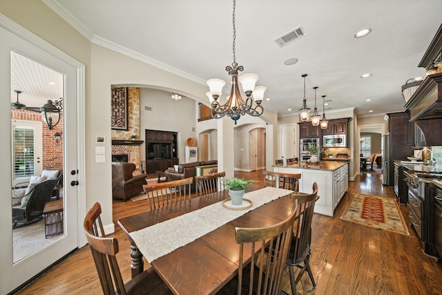 77 Big Trl, Missouri City, TX 77459 - dining room featuring arched walkways, ornamental molding, wood finished floors, recessed lighting, and a chandelier