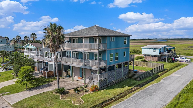 1401 103rd St, Galveston, TX 77554 - exterior space with a balcony, driveway, and a shingled roof