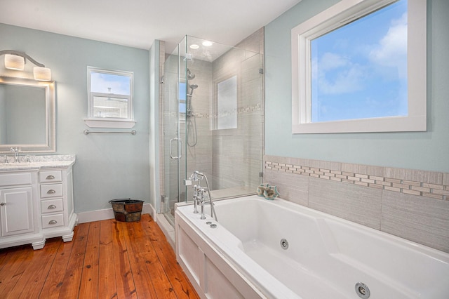 1401 103rd St, Galveston, TX 77554 - full bath featuring a tub with jets, a shower stall, vanity, hardwood / wood-style flooring, and baseboards