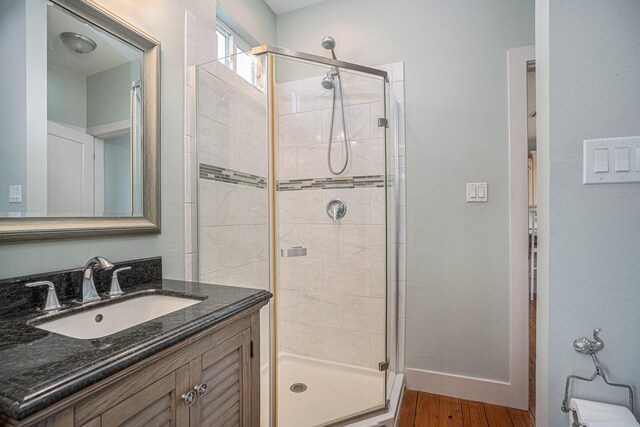 1401 103rd St, Galveston, TX 77554 - full bathroom featuring a shower stall, vanity, wood finished floors, and baseboards