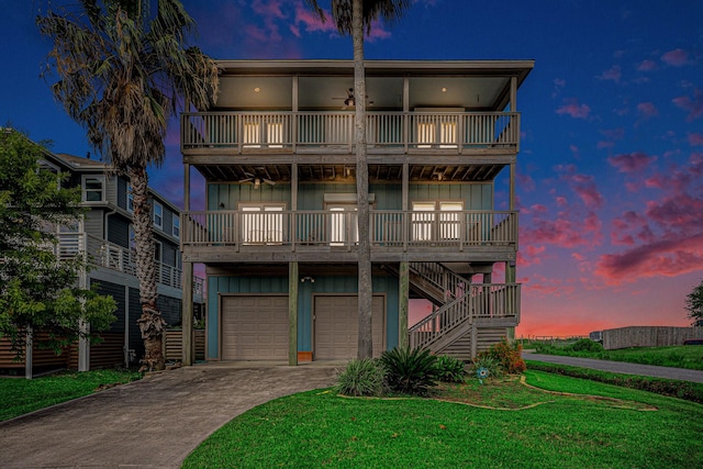 1401 103rd St, Galveston, TX 77554 - view of front facade with board and batten siding, a balcony, driveway, an attached garage, and stairway