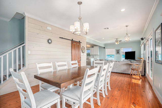 1401 103rd St, Galveston, TX 77554 - dining area with a barn door, crown molding, a ceiling fan, light wood finished floors, and stairway