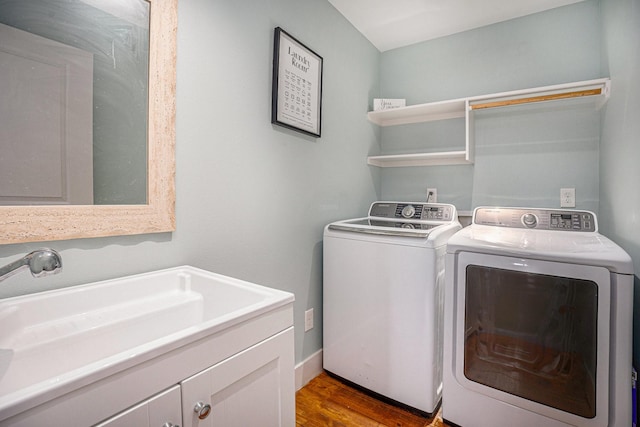 1401 103rd St, Galveston, TX 77554 - washroom with washing machine and clothes dryer, wood finished floors, and cabinet space