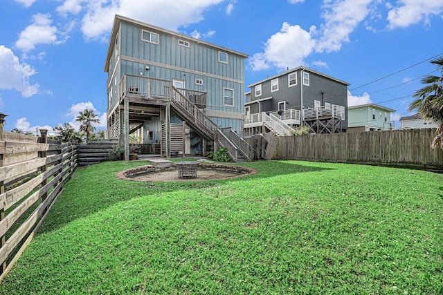 1401 103rd St, Galveston, TX 77554 - rear view of property with stairway, board and batten siding, a fire pit, and a deck