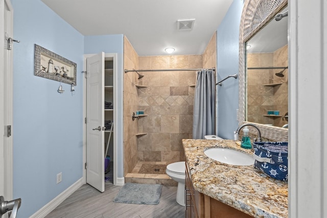 9520 Seawall Blvd Unit 338, Galveston, TX 77554 - bathroom featuring vanity, a shower stall, toilet, wood finished floors, and baseboards