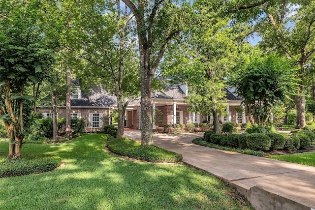 74 Grogans Point Rd, The Woodlands, TX 77380 - obstructed view of property with a front yard and brick siding