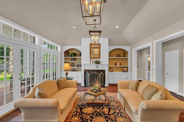 74 Grogans Point Rd, The Woodlands, TX 77380 - living area with a chandelier, lofted ceiling, built in features, dark wood-style floors, and a fireplace with flush hearth