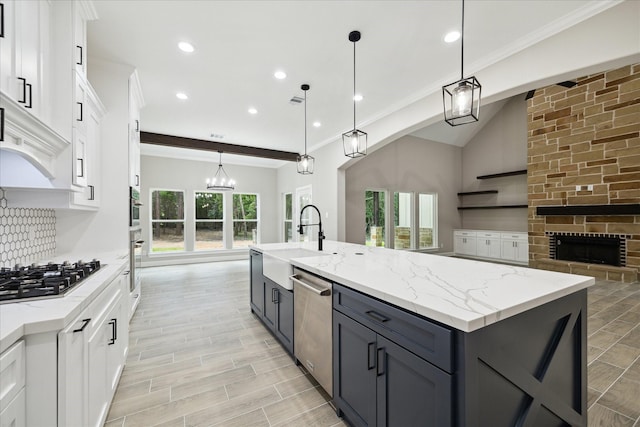26800 Saddle Horn, Waller, TX 77484 - kitchen with stainless steel appliances, a sink, open floor plan, white cabinets, and ornamental molding
