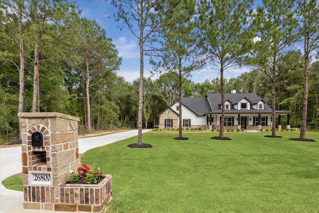 26800 Saddle Horn, Waller, TX 77484 - view of front of property featuring a front lawn, a porch, a chimney, view of scattered trees, and driveway