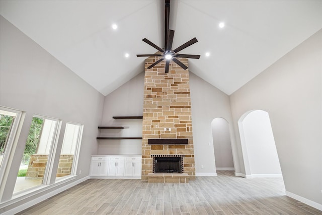 26800 Saddle Horn, Waller, TX 77484 - unfurnished living room featuring high vaulted ceiling, a ceiling fan, light wood-type flooring, arched walkways, and baseboards