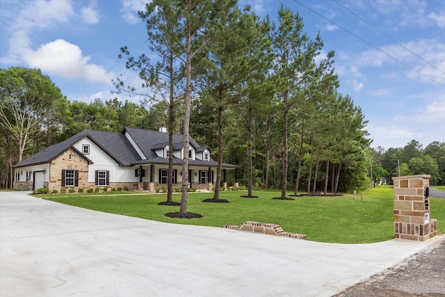 26800 Saddle Horn, Waller, TX 77484 - view of front facade with stone siding, a front lawn, concrete driveway, and view of scattered trees