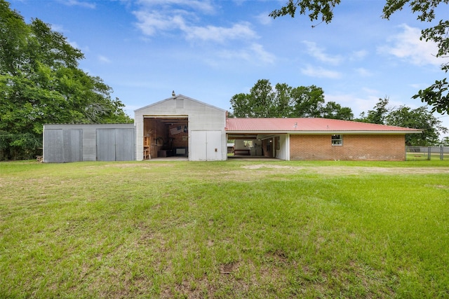 2715 Tinkler St, Rock Island, TX 77470 - back of house with a detached garage, a pole building, an outdoor structure, metal roof, and brick siding
