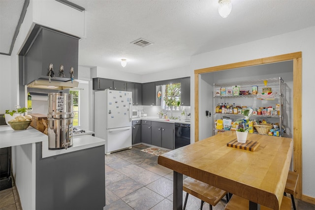 2715 Tinkler St, Rock Island, TX 77470 - kitchen featuring freestanding refrigerator, black dishwasher, healthy amount of natural light, gray cabinets, and a textured ceiling