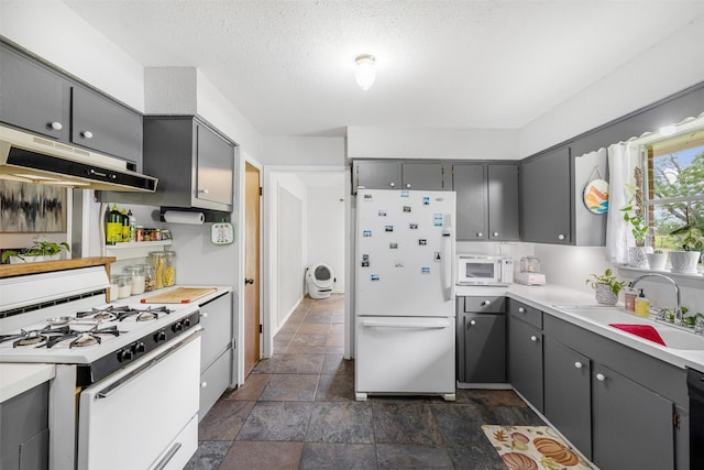 2715 Tinkler St, Rock Island, TX 77470 - kitchen with white appliances, gray cabinetry, under cabinet range hood, a sink, and stone finish floors