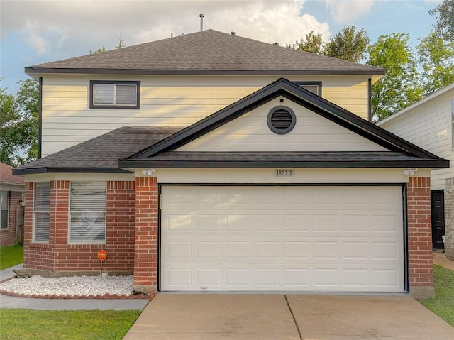 18323 River Sage Dr, Houston, TX 77084 - view of front facade featuring a shingled roof, driveway, brick siding, and an attached garage