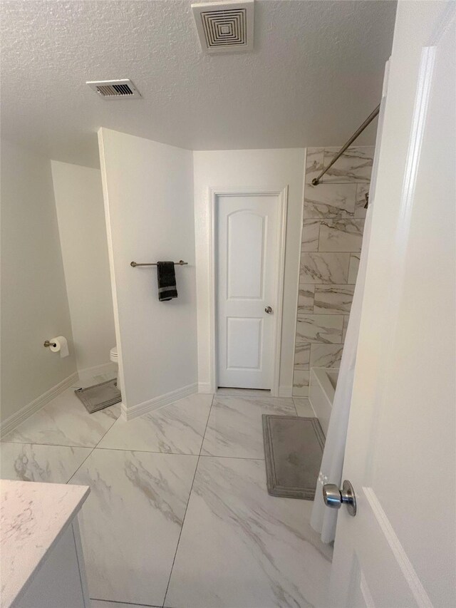 18323 River Sage Dr, Houston, TX 77084 - full bathroom with marble finish flooring, vanity, a textured ceiling, baseboards, and toilet