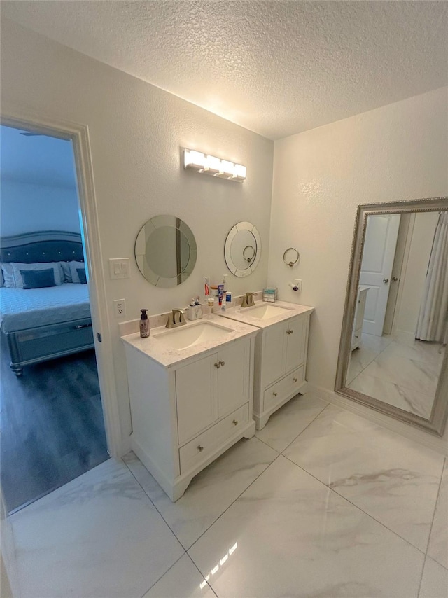 18323 River Sage Dr, Houston, TX 77084 - full bath with ensuite bath, a textured ceiling, vanity, and marble finish flooring