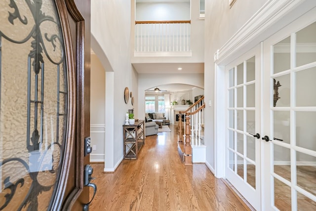 2803 Canyon Dr, Pearland, TX 77584 - foyer featuring arched walkways, french doors, a towering ceiling, wood finished floors, and stairs