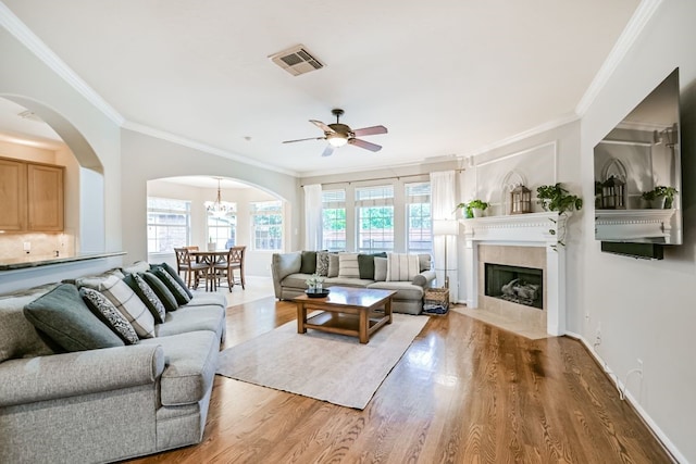 2803 Canyon Dr, Pearland, TX 77584 - living area featuring arched walkways, a ceiling fan, ornamental molding, wood finished floors, and a tiled fireplace