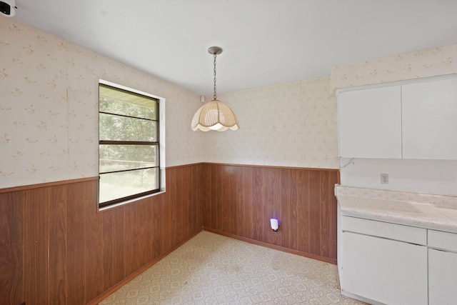 6027 Dellfern Dr, Houston, TX 77035 - unfurnished dining area featuring a wainscoted wall, wooden walls, and wallpapered walls
