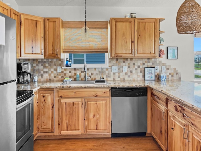 753 Bluewater Hwy, Surfside Beach, TX 77541 - kitchen with stainless steel appliances, a sink, tasteful backsplash, and light wood-style flooring