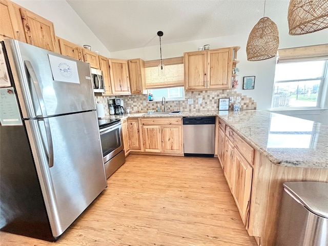 753 Bluewater Hwy, Surfside Beach, TX 77541 - kitchen featuring stainless steel appliances, light brown cabinetry, a sink, vaulted ceiling, and a peninsula