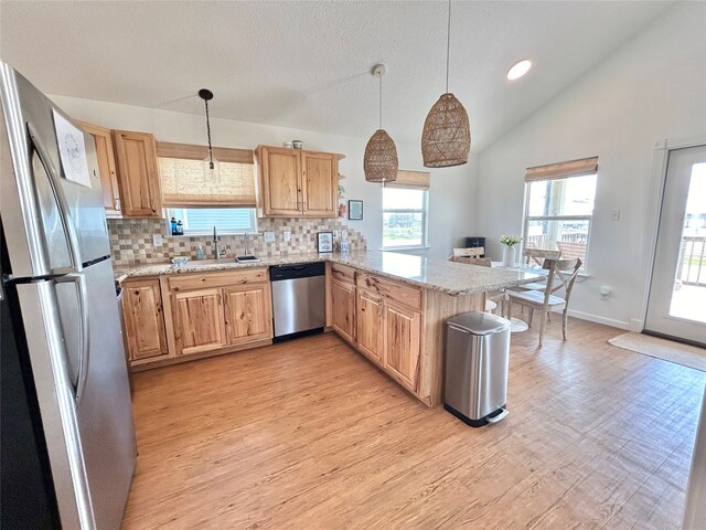 753 Bluewater Hwy, Surfside Beach, TX 77541 - kitchen with appliances with stainless steel finishes, a sink, a peninsula, backsplash, and light wood-style flooring
