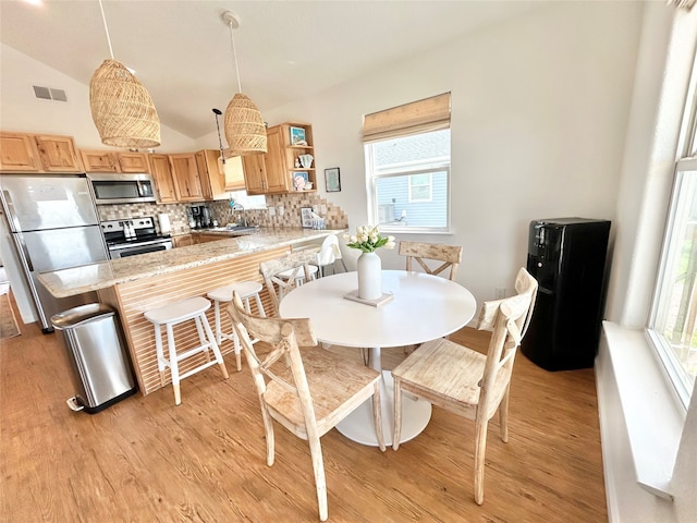 753 Bluewater Hwy, Surfside Beach, TX 77541 - dining area featuring light wood-style flooring, lofted ceiling, and healthy amount of natural light