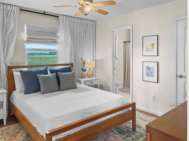 753 Bluewater Hwy, Surfside Beach, TX 77541 - bedroom featuring wood finished floors, baseboards, ensuite bathroom, and a ceiling fan