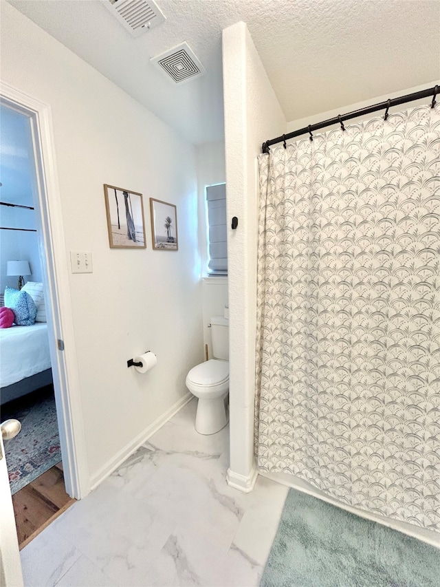 753 Bluewater Hwy, Surfside Beach, TX 77541 - ensuite bathroom with toilet, marble look tiles, baseboards, a textured ceiling, and a shower with shower curtain
